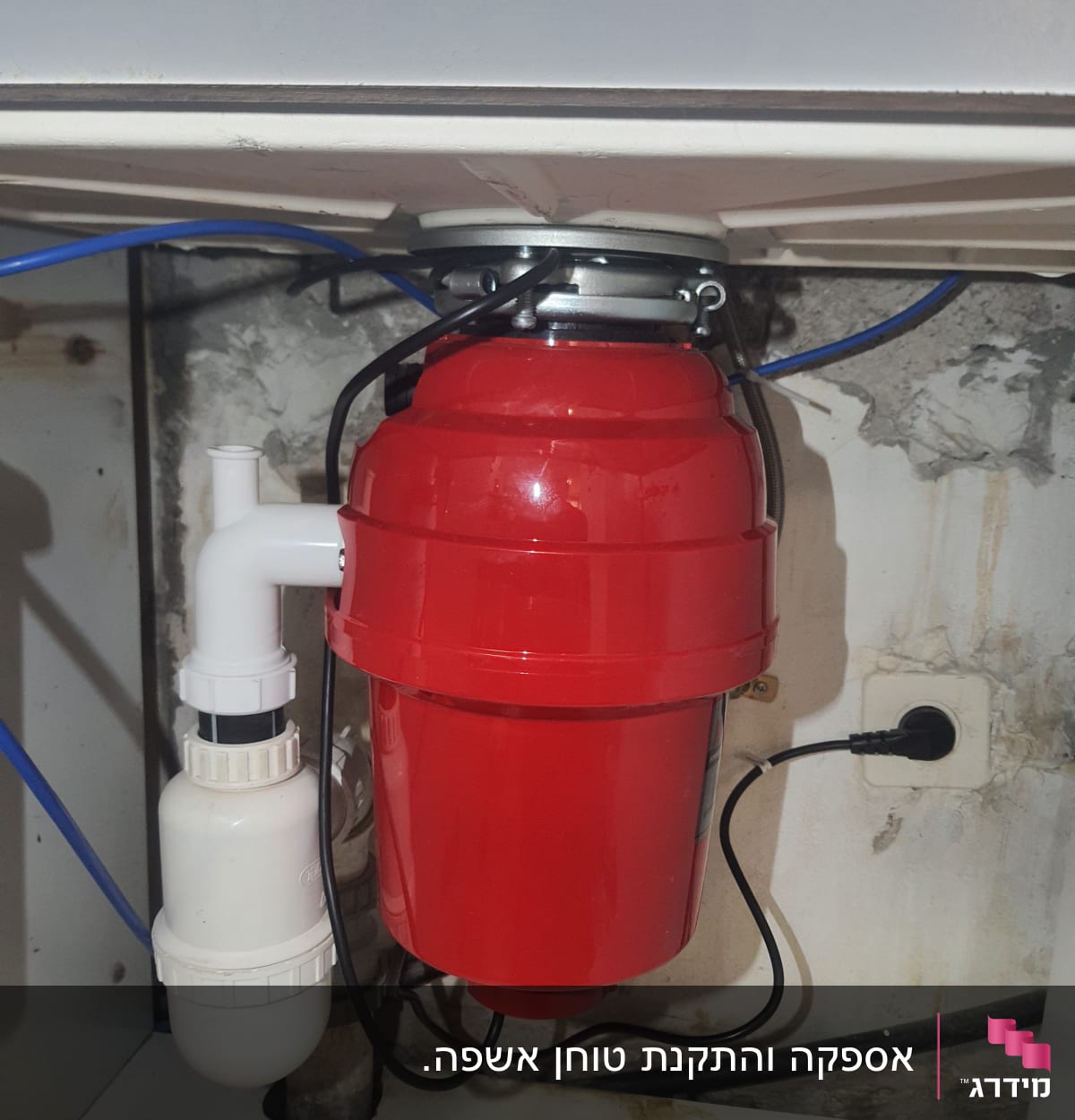 מתקן אדום מתחת לכיור עם צינורות וחיבורים